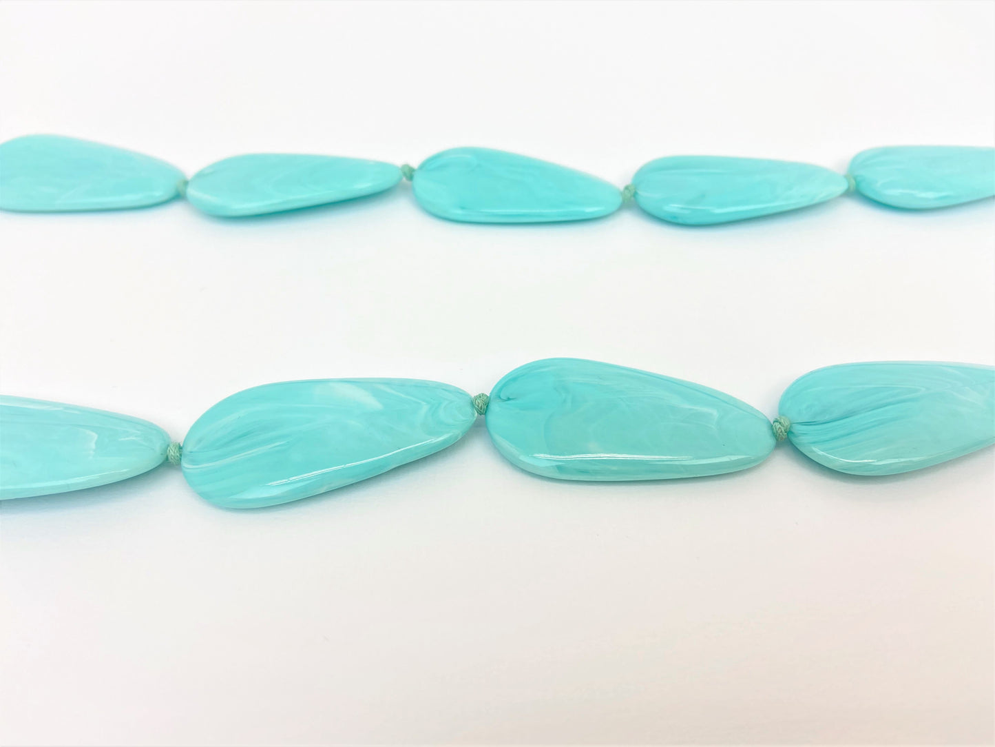 Poolside Pebble Necklace by Stage Jewellery with flat beads in cyan blue tones
